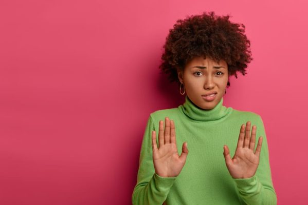 Awkward,Unimpressed,Woman,With,Afro,Hairstyle,,Pulls,Palms,Towards,Camera,